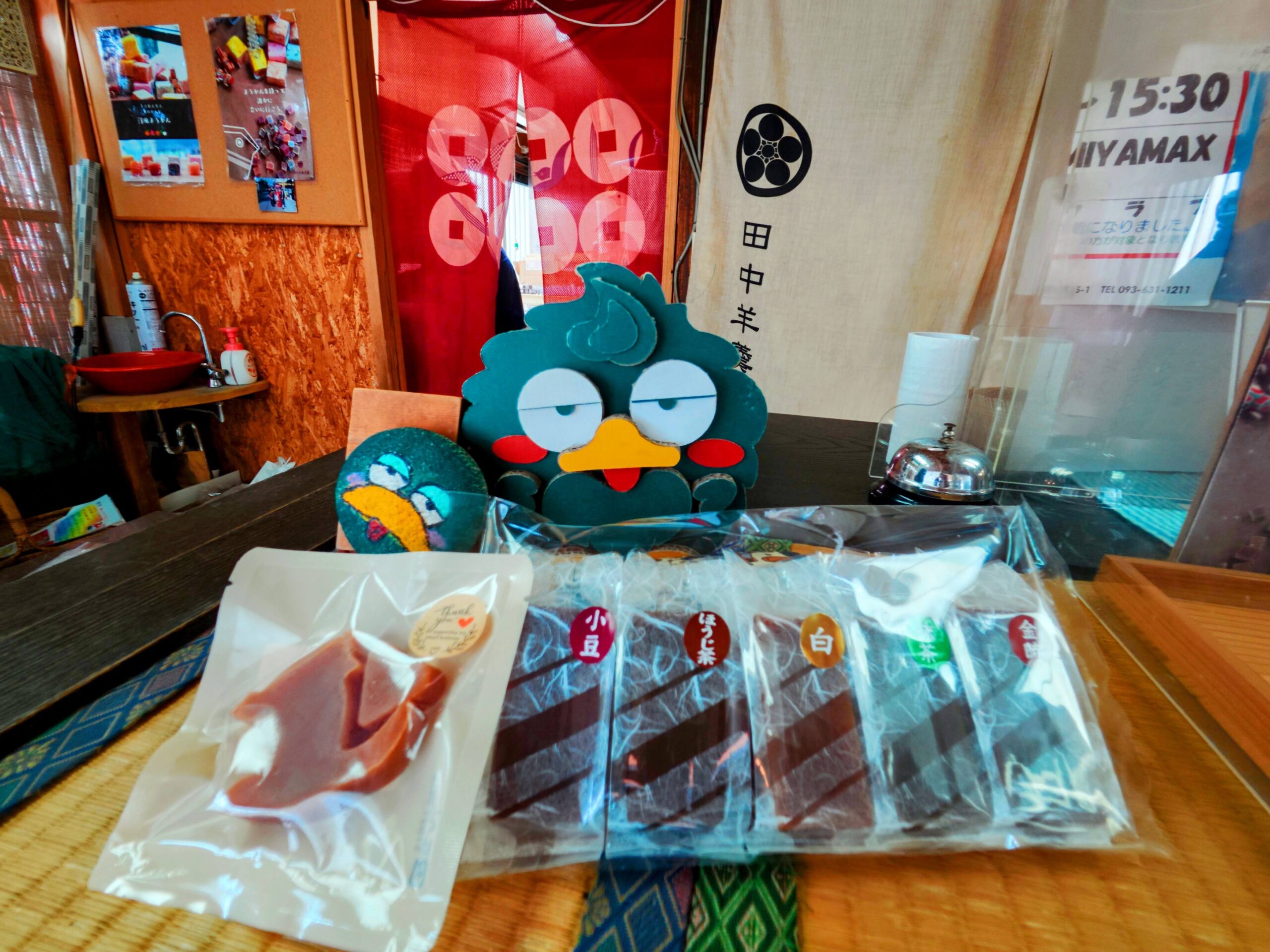 購入した昔ようかんの食べ比べセット、ねこちゃんようかんと、店員さんが貸してくれた矢部川のマスコット「くすべぇ」のぬいぐるみ。